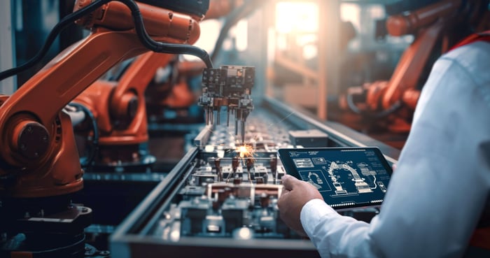 industrial automation robot arm engineer with touchpad