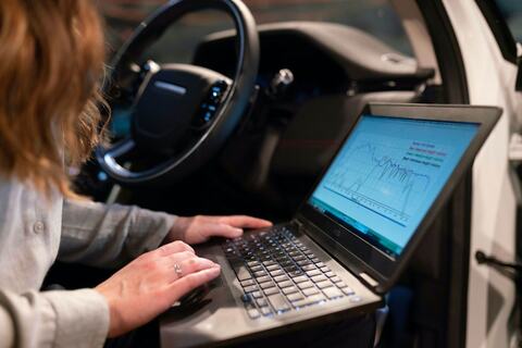 車の中でコードを表示した女性のラップトップ